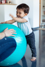 Happy Baby Smiling While Having Fun With Blue Ball At Home.