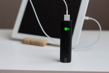 power Bank charges your tablet on a wooden stand