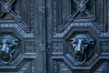 A Pair Of Egyptian Style Carved Cheetah Head Door Handles With Plain Ring Through Their Mouths Adorn A Set Of Decorative Victorian Mausoleum Doors In Highgate West Cemetery, London, UK.
