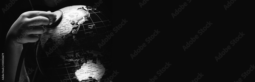 Kid hold globe put stethoscope on sphere isolated on black horizontal background. Ecological problems disasters. COVID-19 pandemic infection disease concept image, copy space for text. BW image - obrazy, fototapety, plakaty 