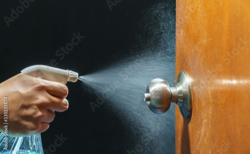 Fotomural Cleaning door knob with alcohol spray for Covid-19 (Coronavirus) prevention