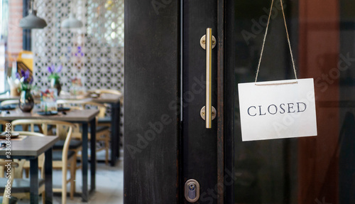 Fotografía closed sign hanging outside a restaurant, store, office or other