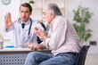 © Elnur - Young male doctor and old patient in antismoking concept
