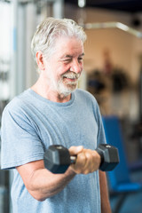 one mature man doing exercise holding one dumbbell alone in the gym to be fit and healthy - lifestyle and concept - senior or pensioner