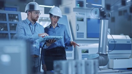 Aufkleber - Factory Workshop: Professional Female Engineer, Male Machinery Operator Use Industrial Digital Tablet Computer to Work and Program Robot Arm for Production Line. High-Tech Facility with CNC Machines