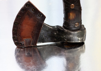 hand-forged axe close-up. decorated with leather and cover