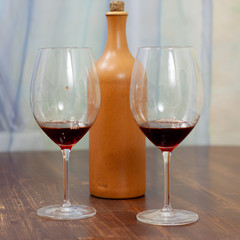 a bottle of homemade wine with two glasses on the table