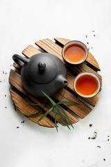 Wall Mural - Asian food background with a tea set, cups, and teapot with free space for text on white stone background. Flat lay asian tea background.