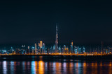 Fototapeta Londyn - Dubai Skyline Taken at Night Showing Burj Khalifa and Dubai Downtown, Reflected on Dubai Creek