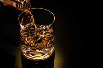 Wall Mural - glass of whiskey on black background