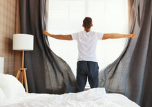 Anonymous Man Pulling Curtains In Morning.