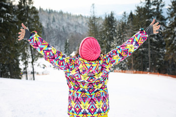 Poster - Young woman at mountain resort, back view. Winter vacation