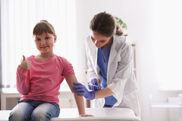 Wall Mural - Little girl receiving chickenpox vaccination in clinic. Varicella virus prevention