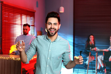 Wall Mural - Young man with Mexican Tequila shot in bar