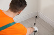 © New Africa - Pest control worker spraying insecticide on floor indoors