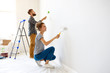 © JenkoAtaman - Happy couple painting wall together.