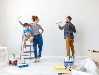 Wall Mural - renovation in apartment. Happy family mother, father and child daughter  paints wall .