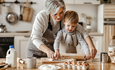 Wall Mural - Grandmother and grandson rolling dough together.