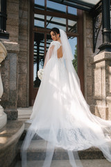 Gorgeous bride in elegant wedding dress with bouquet of white flowers in her wedding day