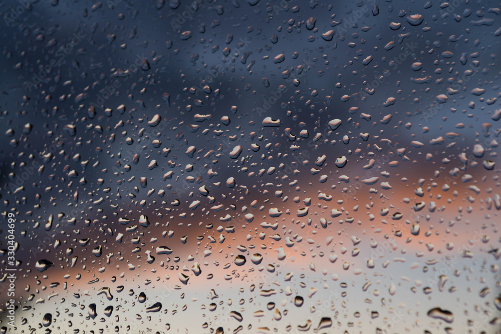Okienna szyba pokryta kroplami deszczu. - obrazy, fototapety, plakaty 
