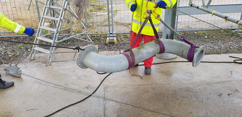 riggers move the pipe using two chain blocks