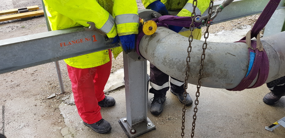 riggers move the pipe using two chain blocks Stock Photo | Adobe Stock