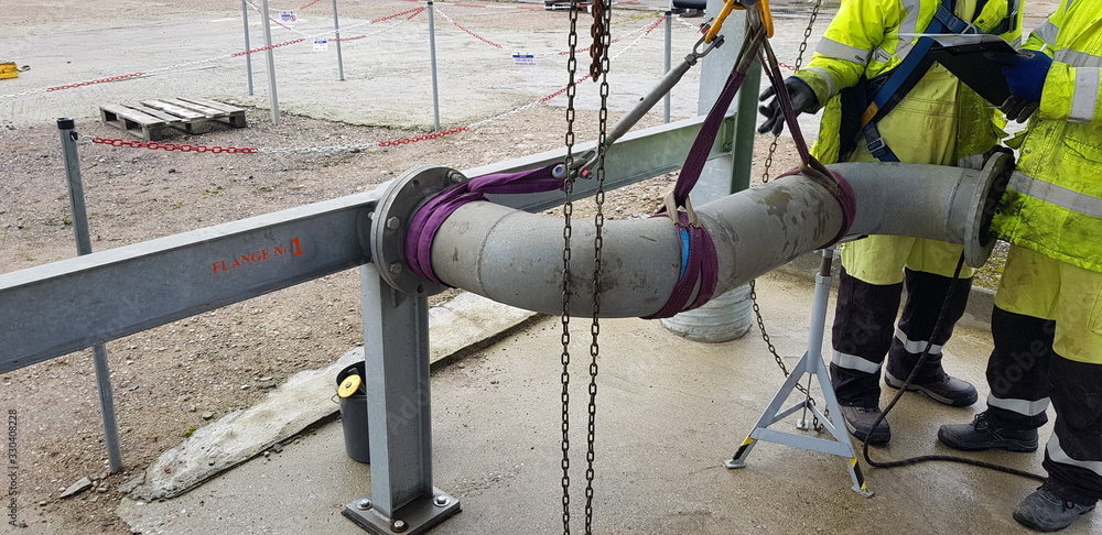riggers move the pipe using two chain blocks Stock Photo | Adobe Stock