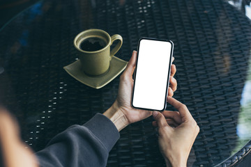 Mockup image blank white screen cell phone.woman hand holding texting using mobile on desk at coffee shop.background empty space for advertise text.people contact marketing business,technology