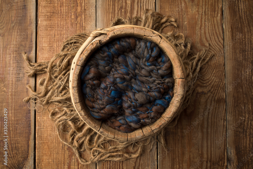 Newborn photography digital background prop. wood basket with blue fur and on a wooden background. - obrazy, fototapety, plakaty 