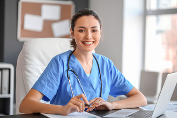 Canvas Print - Young female doctor working in clinic