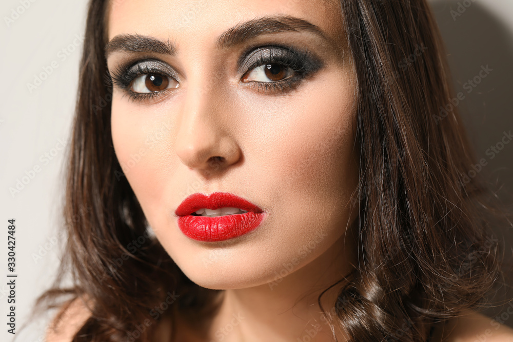 Young woman with beautiful makeup on light background