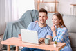 © Pixel-Shot - Happy young couple with laptop at home
