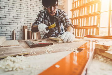 carpenter working on wood craft at workshop to produce construction material or wooden furniture. th