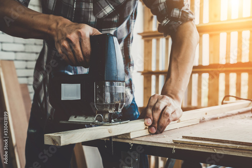 Fotomural Carpenter working on wood craft at workshop to produce construction material or wooden furniture