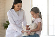 © fizkes - Cute small child patient pretending to be doctor, holding teddy toy at meeting with general practitioner. Friendly nurse showing how stethoscope works to smiling little girl at checkup in clinic.