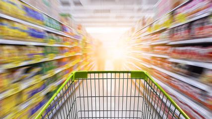 Wall Mural - Supermarket aisle with empty green shopping cart.