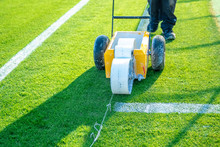 Drawn White Lines On The Football Field With White Paint On The Grass Using A Special Machine Before A Game