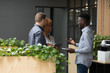 © fizkes - Smiling diverse employees talking, chatting in modern office during break, happy African American businessman sharing good news, discussing project with colleagues, having pleasant conversation