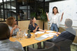 © fizkes - Businesswoman team leader explaining strategy to diverse colleagues, making flip chart presentation at briefing, mentor teacher speaking at meeting, staff training, business partners negotiation