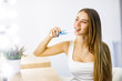© Тарас Нагирняк - A young beautiful girl brushes her teeth with an electric toothbrush in front of a mirror. Oral hygiene.
