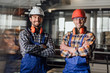 © Тарас Нагирняк - Two young builders in working uniform and helmets crossed arms.
