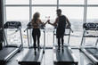 © Тарас Нагирняк - Photo of the back, young sports couple making cardio workout in modern gym