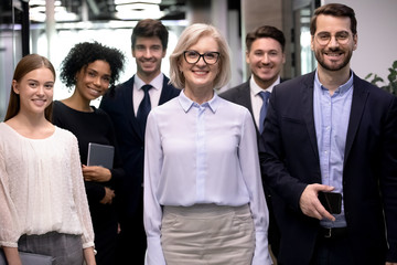 group picture of smiling multiracial employees team pose together looking at camera in office, happy