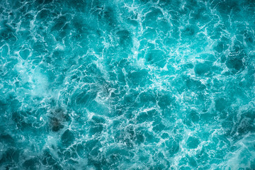 texture light blue surface of raging sea water with white foam and wave pattern