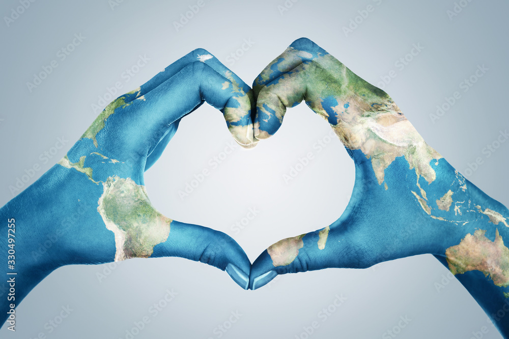Female hands, painted in the world map,  forming heart shape isolated on blue background - obrazy, fototapety, plakaty 