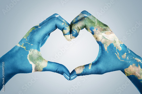 Fotografía Female hands, painted in the world map, forming heart shape isolated on blue ba