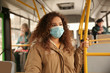 © New Africa - African-American woman with disposable mask on bus. Virus protection