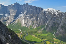 Troll Wall, Norway - June 1,2019. The Highest Vertical Cliff In Europe. Troll Wall And The Green Valley Below It, Seen From Romsdalshornet.