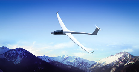 The glider is flying in the mountains