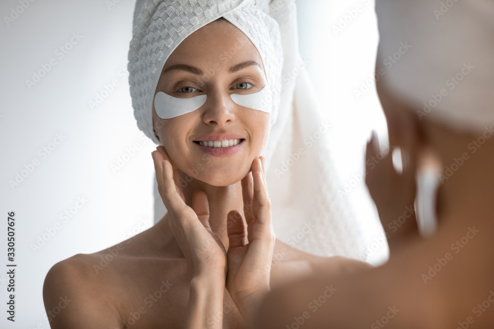Mirror reflection attractive 30s lady with eye area care patches, head shot close up. Smiling pretty woman reducing facial wrinkles, moisturizing skin under eyes, looking at camera. skincare routine. - obrazy, fototapety, plakaty 